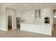 Bright kitchen with white cabinetry, a large island, stainless steel appliances and pendant lighting at 1244 N 106Th Pl, Mesa, AZ 85207