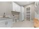 Functional laundry room featuring ample storage and a utility sink, combining convenience with style at 1244 N 106Th Pl, Mesa, AZ 85207