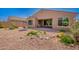 Landscaped backyard featuring a covered patio, decorative gravel, and a comfortable porch swing for relaxing at 14390 W Desert Flower Dr, Goodyear, AZ 85395