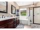 Bathroom with dark wood vanities, double sinks, and a separate shower and tub at 14390 W Desert Flower Dr, Goodyear, AZ 85395