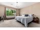 Bright bedroom with large window views to the yard and neutral decor at 14390 W Desert Flower Dr, Goodyear, AZ 85395