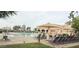 Community pool area with lounge chairs, shade umbrellas and clubhouse in background at 14390 W Desert Flower Dr, Goodyear, AZ 85395