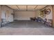 Spacious garage with an automatic door, a side entrance door, and a concrete floor covered with inlaid pavers at 14390 W Desert Flower Dr, Goodyear, AZ 85395