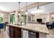 Open-concept kitchen with granite countertops, modern appliances, and views into the living room at 14390 W Desert Flower Dr, Goodyear, AZ 85395