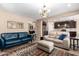 Open-concept living room flowing into the kitchen, with comfortable seating, a large area rug, and ample lighting at 14390 W Desert Flower Dr, Goodyear, AZ 85395