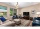 Bright living room featuring a large window, comfortable seating, and a colorful area rug for a cozy atmosphere at 14390 W Desert Flower Dr, Goodyear, AZ 85395