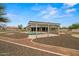 An expansive backyard showcases a sparkling swimming pool, covered patio, and mature desert landscaping at 14539 W Becker Ln, Surprise, AZ 85379