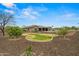 This serene backyard has grass, desert landscaping, pool, hot tub, and covered patio at 14539 W Becker Ln, Surprise, AZ 85379
