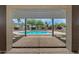 Framed view of a sparkling pool and lush backyard oasis from the covered patio at 14539 W Becker Ln, Surprise, AZ 85379