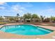 Inviting backyard pool featuring desert landscaping, a shaded pergola, and lush greenery at 14539 W Becker Ln, Surprise, AZ 85379