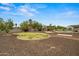 Well-maintained backyard boasting a grassy area, desert landscaping, covered patios, and a refreshing pool at 14539 W Becker Ln, Surprise, AZ 85379