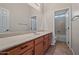 Bathroom featuring a large mirror, neutral countertops, tile flooring, and a door that opens to the shower at 14539 W Becker Ln, Surprise, AZ 85379