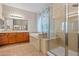A bathroom featuring dual sinks, soaking tub, and glass shower at 14539 W Becker Ln, Surprise, AZ 85379