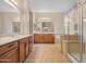 Bathroom with dual vanities, mirrors, soaking tub, and glass shower at 14539 W Becker Ln, Surprise, AZ 85379