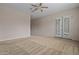 Spacious bedroom with neutral tones, ceiling fan, and access to outdoor space at 14539 W Becker Ln, Surprise, AZ 85379