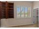 Bedroom with built-in cabinets and a large window with plantation shutters at 14539 W Becker Ln, Surprise, AZ 85379