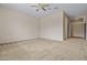 Neutral-toned bedroom with ceiling fan and carpet flooring, leading to a closet at 14539 W Becker Ln, Surprise, AZ 85379
