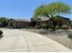 Desert home with circular driveway, gravel landscaping, mature trees, and a neutral color palette at 14539 W Becker Ln, Surprise, AZ 85379
