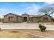 Sprawling single-story home boasting mature desert landscaping, a circular driveway, and a water feature at 14539 W Becker Ln, Surprise, AZ 85379