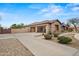 Charming single-story home featuring a three-car garage, mature landscaping, and an inviting entrance at 14539 W Becker Ln, Surprise, AZ 85379