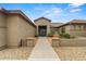 Inviting single-story home with a walkway leading to the front door and a well-maintained desert landscape at 14539 W Becker Ln, Surprise, AZ 85379