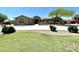 Charming single-story home featuring a lush green lawn, mature landscaping, and a circular driveway at 14539 W Becker Ln, Surprise, AZ 85379