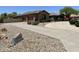 Home featuring a spacious two-car garage, circular driveway, desert landscaping, and mature landscaping at 14539 W Becker Ln, Surprise, AZ 85379