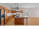 Spacious kitchen featuring wood cabinetry, granite countertops, and a large center island with a sink at 14539 W Becker Ln, Surprise, AZ 85379