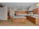 Bright kitchen showcasing a large center island, wood cabinets, and granite countertops at 14539 W Becker Ln, Surprise, AZ 85379
