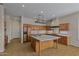 Large kitchen with granite counters, wooden cabinets, and center island with hanging pot rack at 14539 W Becker Ln, Surprise, AZ 85379