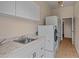 Convenient laundry room with sink, cabinets, and modern appliances for efficient chores at 14539 W Becker Ln, Surprise, AZ 85379