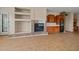Living room features custom built-ins, a wine cooler, and a fireplace, flowing into the kitchen at 14539 W Becker Ln, Surprise, AZ 85379
