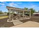 Stylish pergola with a dining set and fire pit, creating an outdoor oasis for relaxation and entertainment at 14539 W Becker Ln, Surprise, AZ 85379