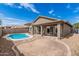 Backyard with a pool, patio area, and desert landscaping for easy maintenance at 15829 W Boca Raton Rd, Surprise, AZ 85379