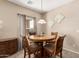 Dining area with round wooden table and upholstered chairs under a decorative pendant light at 15829 W Boca Raton Rd, Surprise, AZ 85379