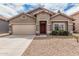 Charming single-story home featuring a two-car garage and a well-maintained front yard at 15829 W Boca Raton Rd, Surprise, AZ 85379