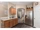 Kitchen area featuring granite countertops, stainless steel refrigerator, wood cabinets, and nearby doorway at 15829 W Boca Raton Rd, Surprise, AZ 85379