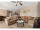 Spacious living room boasts a large sectional sofa, neutral decor, and seamless flow into the adjacent kitchen at 15829 W Boca Raton Rd, Surprise, AZ 85379