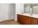 Bathroom features a double vanity with wooden cabinets and tile flooring at 17507 N Costa Brava Ave, Maricopa, AZ 85139