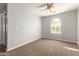 Bedroom with neutral carpet, ceiling fan, and natural light from window at 17507 N Costa Brava Ave, Maricopa, AZ 85139