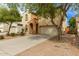 Home featuring a two-car garage, beautiful trees, and desert landscaping at 17507 N Costa Brava Ave, Maricopa, AZ 85139