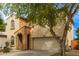 Beautiful exterior view of a home with arched entry, desert landscaping, and two-car garage at 17507 N Costa Brava Ave, Maricopa, AZ 85139