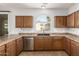 Kitchen with wood cabinets, stainless steel appliances, and a large window over the sink at 17507 N Costa Brava Ave, Maricopa, AZ 85139