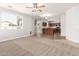 Spacious living room with carpet flooring, ceiling fan, and adjacent kitchen at 17507 N Costa Brava Ave, Maricopa, AZ 85139