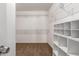 Spacious walk-in closet with carpet flooring, white walls, and metal shelving on the walls and an organized shelving unit at 17507 N Costa Brava Ave, Maricopa, AZ 85139