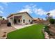 Spacious backyard with lush artificial turf, low maintenance landscaping, and covered patio area at 1770 W Derringer Way, Chandler, AZ 85286