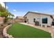 A wide angle shot of the backyard with artifical turf, block wall and covered patio at 1770 W Derringer Way, Chandler, AZ 85286