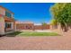 Expansive backyard features sport court, play area, privacy wall and lush tree for added shade at 18318 W Pueblo Ave, Goodyear, AZ 85338