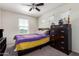 Cozy bedroom featuring natural light, a ceiling fan, and dark wood bedroom furniture set at 18318 W Pueblo Ave, Goodyear, AZ 85338