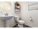 Clean powder room featuring a pedestal sink, decorative mirror, and ample lighting at 18318 W Pueblo Ave, Goodyear, AZ 85338